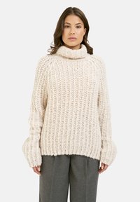 Flauschiger cremefarbener Strickpullover mit hohem Kragen, oversized Schnitt und gerippter Textur. Verfügt über weit geschnittene Ärmel und eine lässige Silhouette.