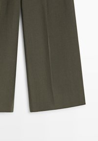 Olivengrønne bukser med brede ben og glat stofstruktur, vist fra midt på låret til kanten mod en hvid baggrund.