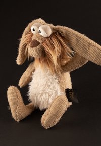 Stuffed animal with beige and cream fur, long floppy ears, and a fuzzy white belly. Features large eyes and a stitched nose.
