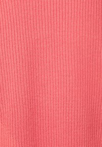 Tessuto a maglia di un vibrante colore corallo con una texture a coste, che offre un aspetto morbido e denso, adatto per abbigliamento.