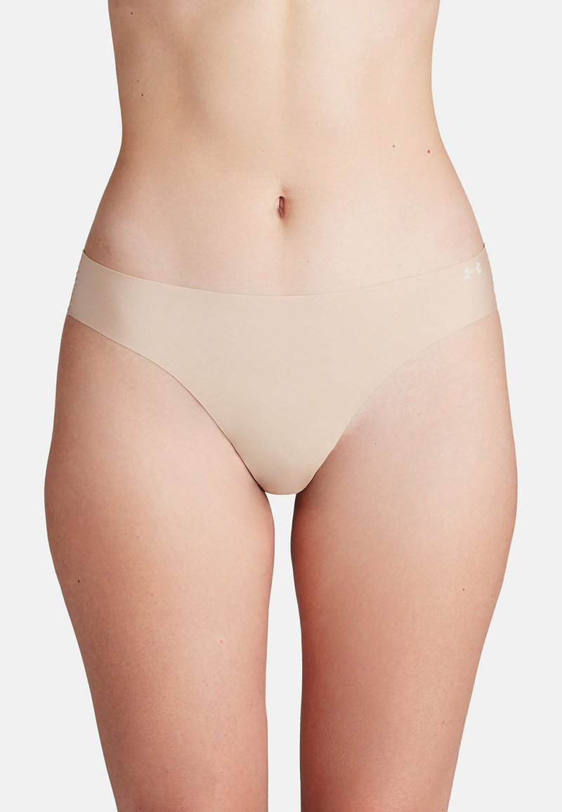 Nude naadloze slipjes met een gladde textuur en minimale bedekking. Kenmerkt zich door een brede waistband en een subtiele merklogo aan de zijkant.
