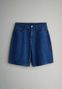 Pantalones cortos de mezclilla azul con botón frontal, trabillas para cinturón, bolsillos delanteros y bolsillo para monedas, mostrados planos sobre un fondo gris.