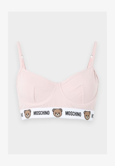 Ανοιχτό ροζ σουτιέν με ρυθμιζόμενες τιράντες, μπανέλες και λευκή ελαστική ταινία με προσωπάκια αρκουδάκια και το κείμενο «MOSCHINO» μαύρο.