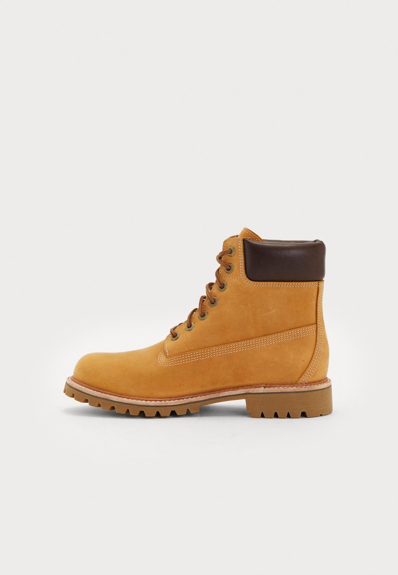 Stivale da lavoro in pelle color cuoio con colletto imbottito marrone scuro, allacciatura frontale e suola spessa e scolpita, mostrato in profilo laterale su sfondo bianco.
