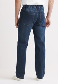 Mörkblå denimjeans med elastisk midjeresår, rak benfasong och två bakfickor, med slät textur och minimal sömnad.
