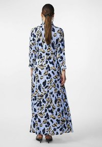 Abito lungo blu con stampa leopardata in nero e color sabbia. Realizzato in tessuto liscio, presenta un collo a camicia e maniche lunghe.