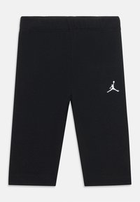 Black leggings made from cotton blend fabric, featuring a snug fit, an elastic waistband, and a white Jumpman logo accent.