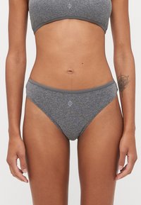 Bas de bikini gris côtelé avec une taille contrastante, mettant en avant un emblème de logo au centre à l'avant et un tissu lisse et texturé.