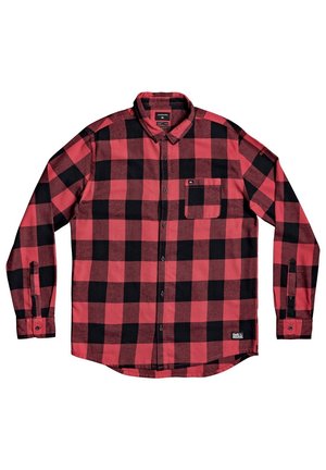Chemise à manches longues boutonnée avec grand motif à carreaux rouges et noirs, poche poitrine et col, posée à plat sur un fond blanc.