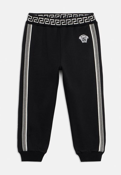 Μαύρο παντελόνι φόρμας με τρεις λευκές ρίγες στα πλάγια, λευκό λογότυπο Μέδουσας στο δεξί μηρό και μαύρη μέση με λευκό σχέδιο ελληνικού κλειδιού.