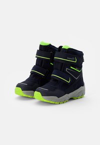 Dunkelblaue Kinderstiefel mit zwei schwarzen Klettverschlüssen, leuchtend grünen Akzenten, strukturiertem Stoff und einer robusten grauen Sohle.