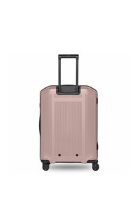 Valise rigide en or rose avec poignée télescopique noire étendue, quatre roues pivotantes noires et design à rainures verticales.