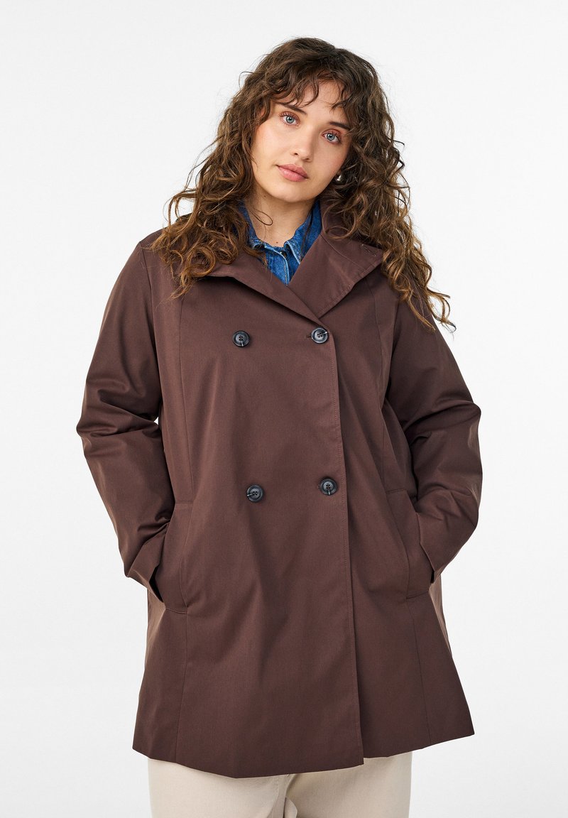 Brauner, doppelt geknöpfter Mantel mit Kragen, zwei Seitentaschen und schwarzen Knöpfen, aus glattem Stoff mit legerer Passform.