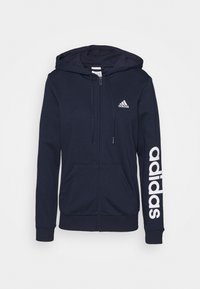 Mörkblå zip-up hoodie i bomullsblandning, med huva, framfickor och stor vit "adidas"-logotyp längs vänster ärm.