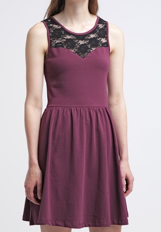 Gaun ungu tanpa lengan dengan bodice bagian atas renda hitam, memiliki pola bunga dan rok mengembang. Terbuat dari kain lembut dan ringan.