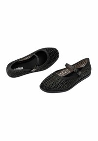 Bailarinas negras con un patrón tejido, punta redonda y una correa con hebilla lateral. Material suave con un acabado texturizado y suela plana.