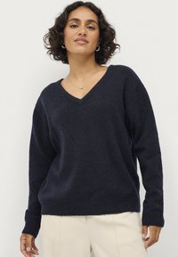 Marineblau, locker gestrickter Pullover mit V-Ausschnitt, langen Ärmeln und gerippten Bündchen. Sanfte Textur, lässige Passform und minimalistisches Design.