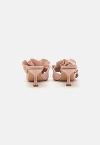 Pantofi cu toc înalt roz, cu un design ondulat, realizați dintr-un material moale, având un toc subțire și o suprafață netedă.