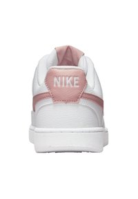 Sneaker bianca con dettagli in pelle rosa, dotata di collo imbottito, retro testurizzato e marchio "NIKE" in bianco sul tallone.