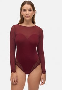 Bodysuit burdeos con mangas largas transparentes. Presenta un escote en forma de corazón y un acabado de encaje en la cintura y las mangas, destacando un diseño ajustado.