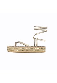 Sandali platform in metallo dorato con dettagli in corda intrecciata e borchie. Presentano un cinturino alla caviglia a spirale e una suola piatta per il supporto.