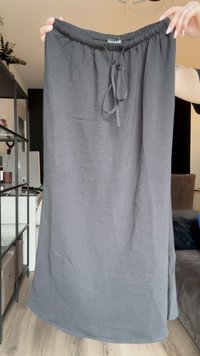 Gonna nera leggera con vita elastica e cordoncino. Caratterizzata da una texture liscia, taglio dritto e spacchi laterali per il comfort.
