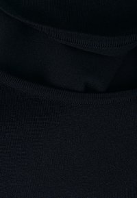Tessuto del maglione lavorato a maglia di un blu scuro, con una superficie liscia. Presenta un collo rotondo e un aspetto a strati con bordi di tessuto sovrapposti.