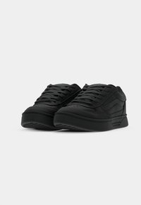 Zwarte sneakers gemaakt van gestructureerd synthetisch materiaal, met een low-top ontwerp, ronde neus en platte rubberen zool met minimale details.