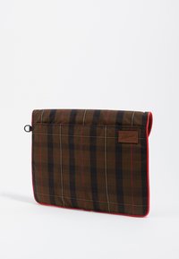 Rudos plaid stiliaus nešiojamojo kompiuterio dėklas su raudonu apvadu, turintis tekstūruotą paviršių, šoninės juostos kilpą ir odinį prekės ženklo ženklą.