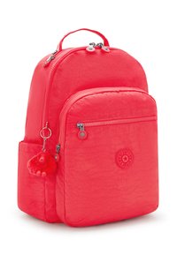 Červený nylonový batoh s texturovaným povrchem, se dvěma zipovými přihrádkami a přívěskem v podobě malé růžové opice.