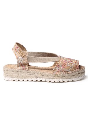 Sandale espadrille beige avec tissu floral brodé, bride élastique à la cheville, semelle plateforme en corde tressée et semelle extérieure en caoutchouc blanc texturé.
