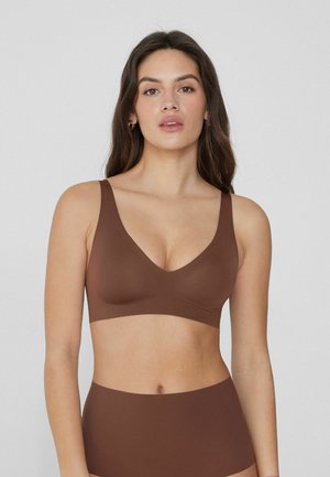 Soutien-gorge marron avec un décolleté en V, des bretelles larges et une texture lisse et sans coutures. Comprend une pièce basse taille haute assortie.