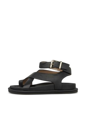 Sandalia de cuero negro con tiras cruzadas, suela plana y correa ajustable en el tobillo con hebilla dorada.