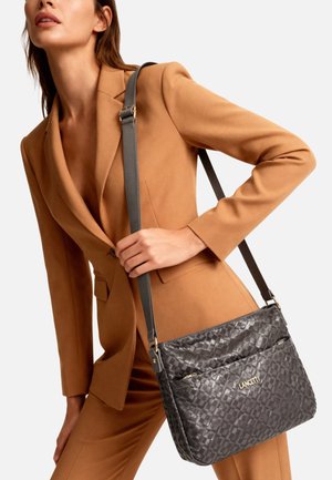 Borsa intrecciata grigia con texture liscia, dotata di due tasche anteriori e una lunga tracolla regolabile. Dettaglio logo dorato ben visibile.