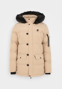 Beige Puffer-Jacke mit einer Kapuze aus Kunstpelz, Druckknopfverschluss, zwei frontalen Klapptaschen und schwarzen Akzenten an den Ärmeln und dem Reißverschluss.