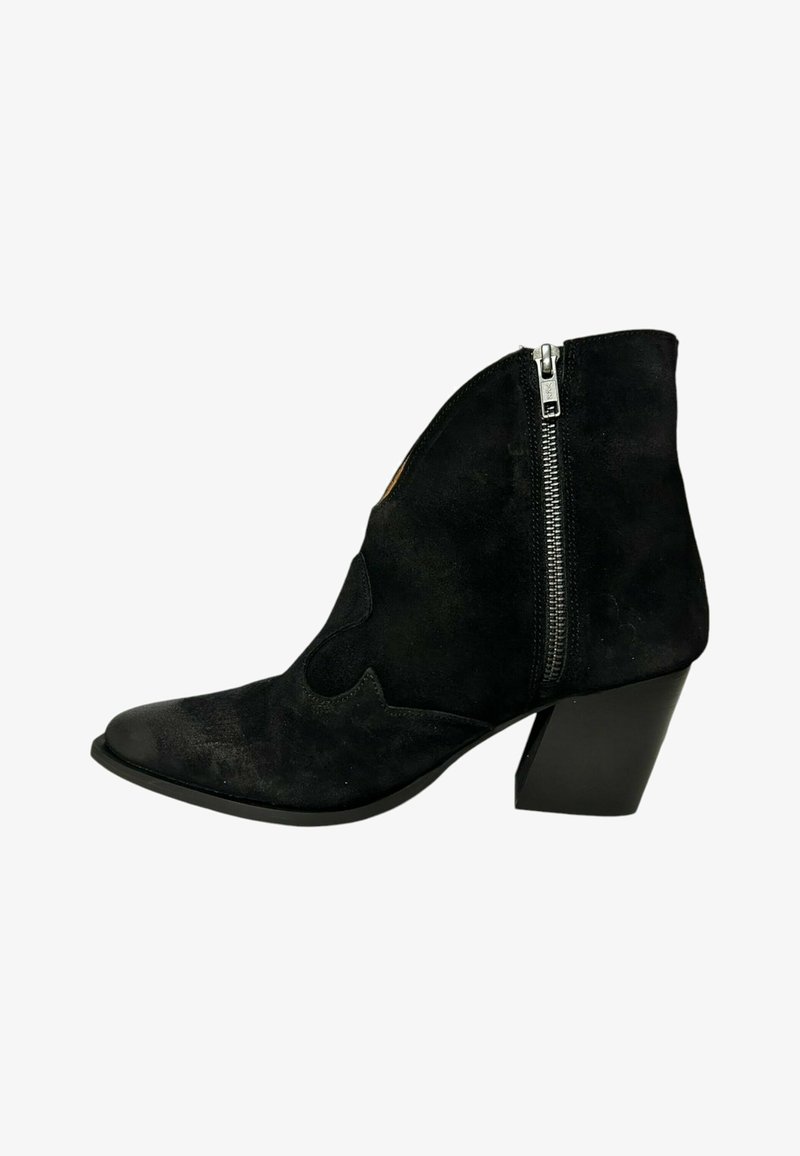 Botín de ante negro hasta el tobillo con punta afilada, detalles recortados y cremallera lateral, con un tacón grueso. Textura suave y diseño elegante.