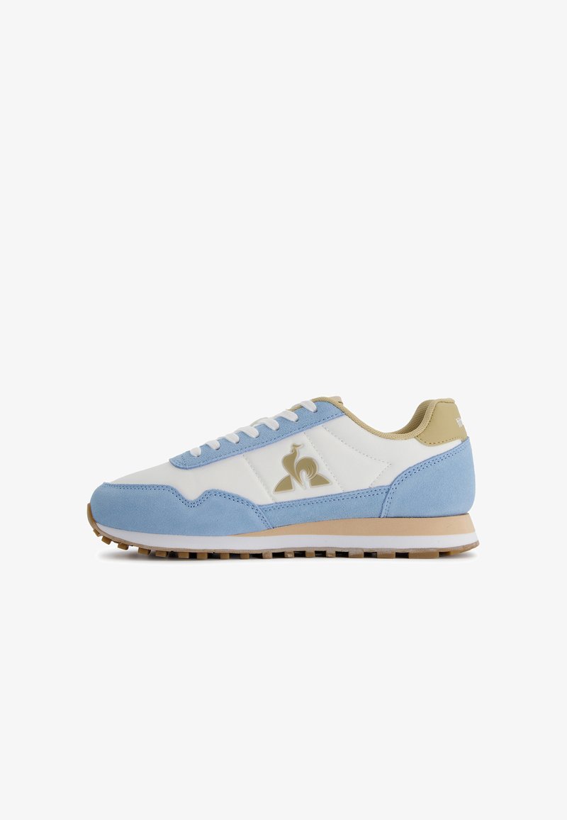 Scarpa sportiva azzurro chiaro e bianca realizzata in materiali scamosciati e in pelle, con suola in gomma, design con lacci e dettaglio del logo dorato.