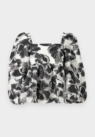 Svart-hvit blomsterbluse med puffermer, firkantet uthuling, teksturert stoff og metalltråd detaljer som gir et lagdelt utseende.