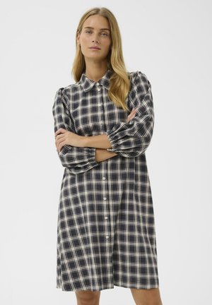 Langärmliges, karierter Hemdkleid in Marineblau, Creme und Beige. Verfügt über einen Kragen, eine Knopfverschluss und gepuffte Ärmel mit elastischen Bündchen.