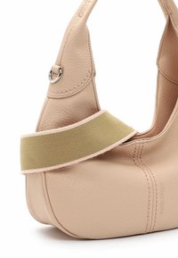 Borsa a mano in pelle beige texturizzata con ampia tracolla in tessuto verde oliva e cuciture visibili, che mostra il dettaglio dell'anello metallico nell'attacco della maniglia.