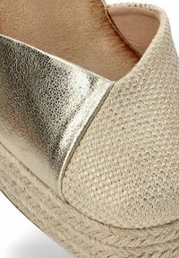 Espadrille tejido con un upper de textil beige con acentos metálicos dorados, suela de yute trenzado y forro interior de cuero suave.