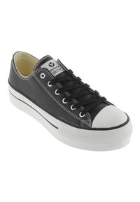 Sneaker nera in tela con suola e punta in gomma bianca. Presenta lacci neri, occhielli in argento e dettagli in bianco nei punti di cucitura.