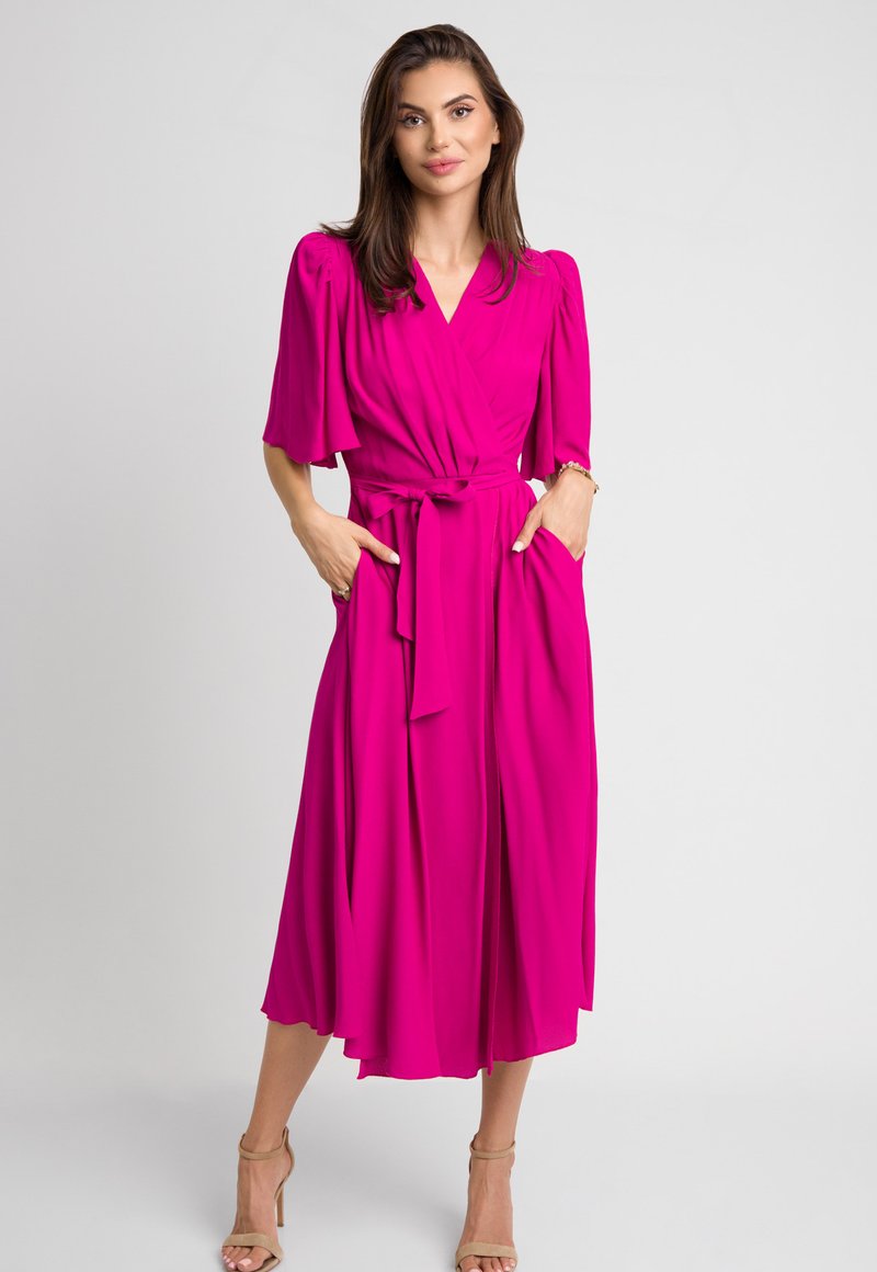 Fuksjowa sukienka wrap z krótkimi bufkami, wiązanym w pasie, bocznymi kieszeniami i zwiewnym dołem. Gładki materiał o lekkiej fakturze.