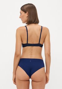 Navyblauw lingeriesetje met een bh met achtersluiting en verstelbare bandjes, vergezeld van bijpassende high-waisted slips, gemaakt van gladde, rekbare stof.