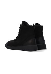 Černé semišové kotníkové boty s hladkým koženým podpatkem, šněrováním v přední části a texturovanou gumovou podrážkou. Vybaveny bočním zipem pro snadné obouvání.