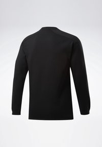 Camisa negra de manga larga con cuello redondo, vista desde la parte posterior, que presenta detalles de costura simples en los hombros y puños ajustados.
