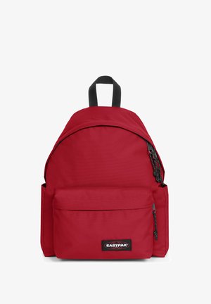 Roter Rucksack mit abgerundetem Oberteil, aus robustem Stoff gefertigt, mit verstellbaren Trägern, einer Fronttasche und einem Logo-Patch.