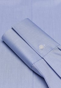 Helles blaues Hemd mit feinen diagonalen Streifen, ausgestattet mit einer geknöpften Manschette und ordentlich gebügeltem Stoff. Weiche Textur und taillierte Passform.