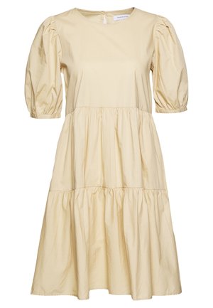 Robe beige jusqu’au genou avec manches courtes bouffantes, encolure ronde et volants froncés le long de la jupe pour une coupe ample.
