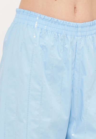 Pantalones cortos de pijama de color azul claro hechos de una tela suave con una cinturilla elástica, que presentan filas verticales de pequeñas lentejuelas para añadir textura y detalle.